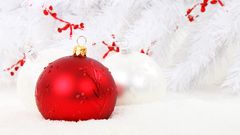 Red and white baubles on a snowy backdrop