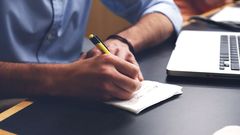 A man's hands writing notes