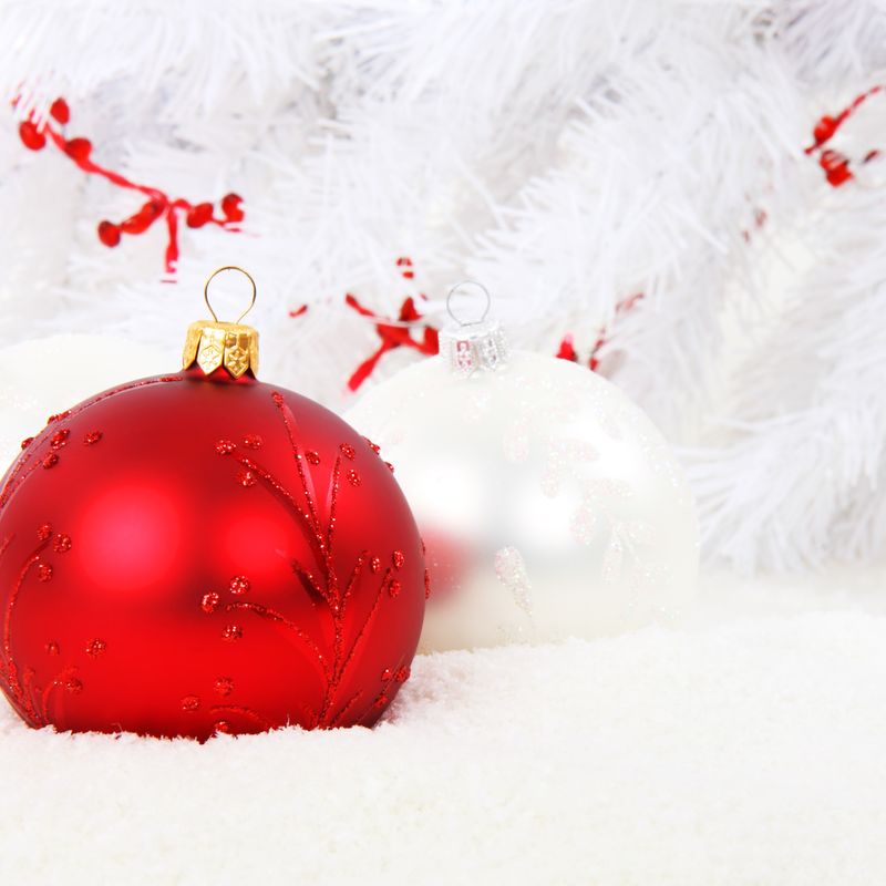 Red and white baubles on a snowy backdrop