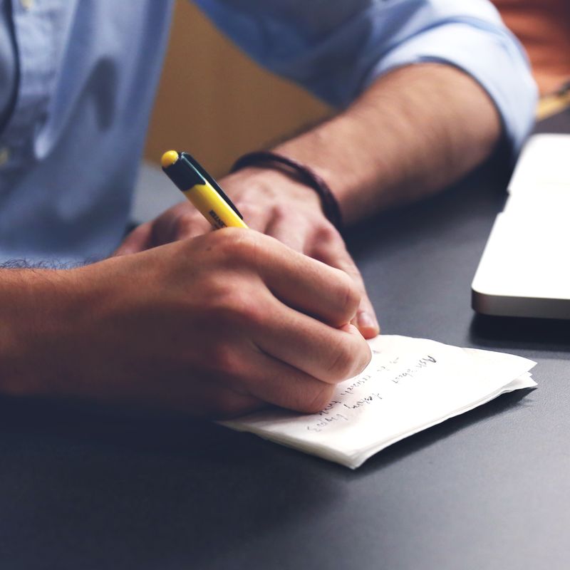 A man's hands writing notes