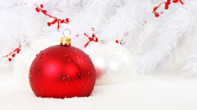 Red and white baubles on a snowy backdrop